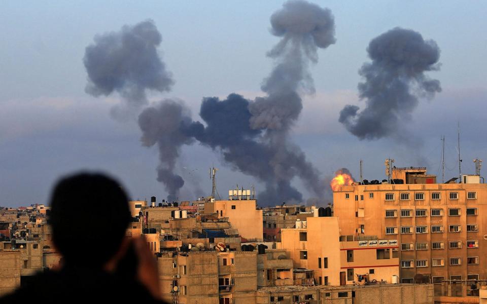 A Palestinian boy watches smoke billowing from targets during Israeli airstrikes on the southern Gaza region of Khan Yunis, controlled by the Hamas movement, on May 11, 2021. - MAHMOUD KHATAB /AFP