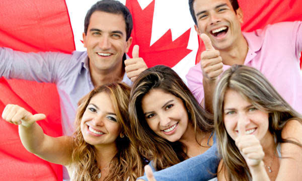 Group of young people with thumbs up and the flag of Canada