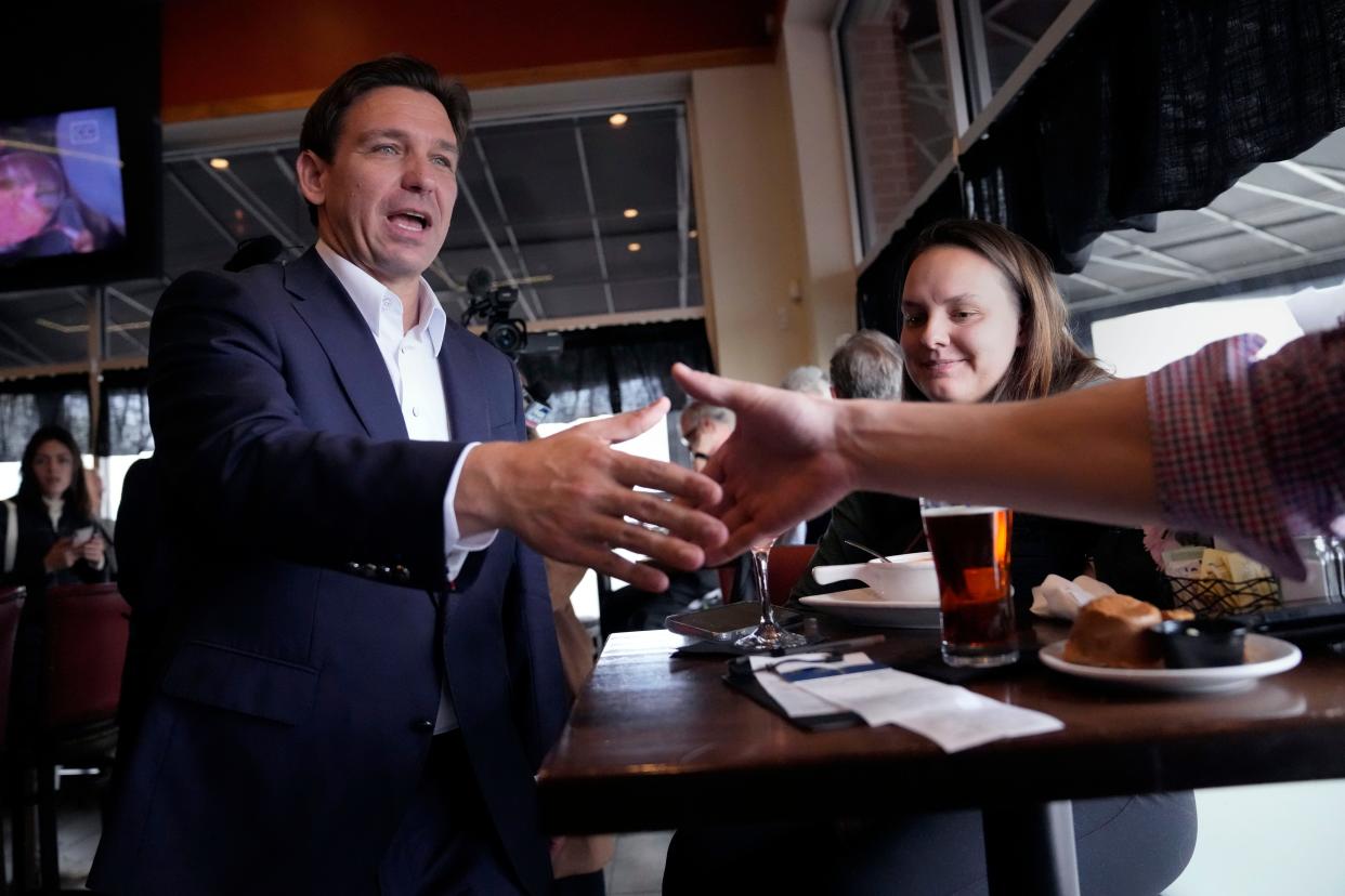 Republican presidential candidate, Florida Gov. Ron DeSantis, shakes hands with a patron during a campaign stop at a restaurant, Tuesday, Oct. 24, 2023, in Epping, New Hampshire.