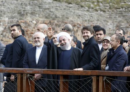 Iran President Hassan Rouhani (C) waves next to Italy's Culture Minister Dario Franceschini (R) during his visit at the Colosseum in Rome, Italy, January 27, 2016. REUTERS/Alessandro Bianchi