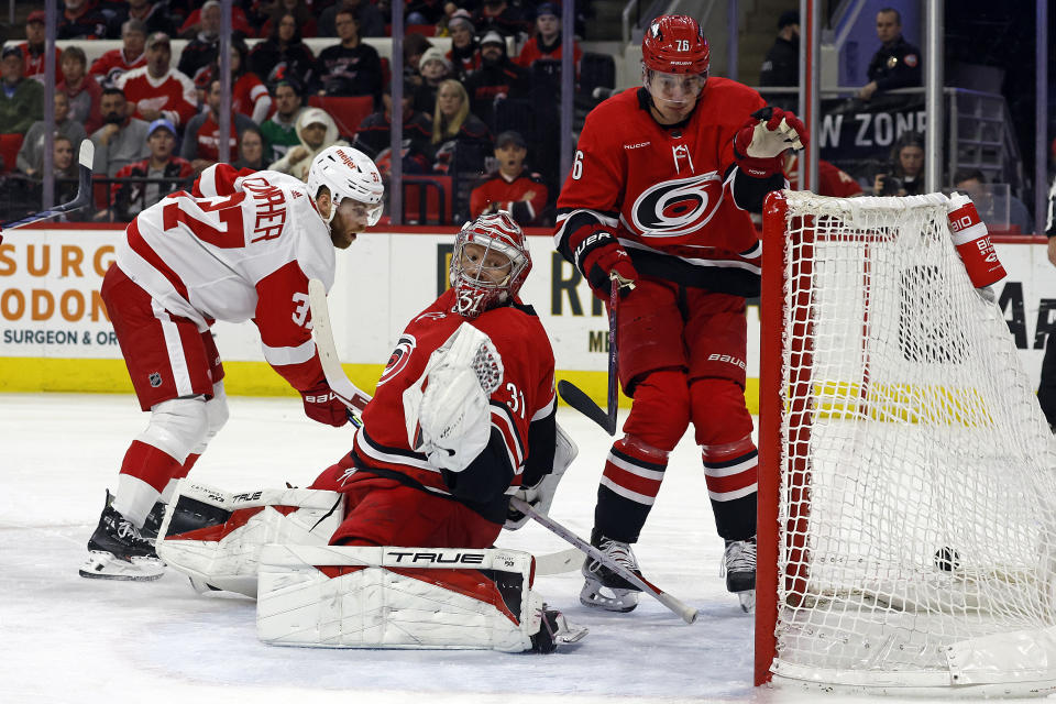 Carolina Hurricanes' Brady Skjei helps goaltender Frederik Andersen in stopping the shot of Detroit Red Wings' J.T. Compher during the first period of an NHL hockey game in Raleigh, N.C., Thursday, March 28, 2024. (AP Photo/Karl B DeBlaker)