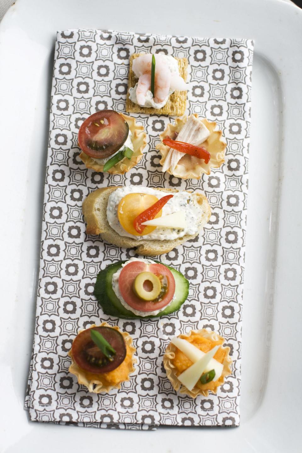 In this Jan. 28, 2013 photo, using our building block approach to Oscar party canapes, diners are able to select from a buffet of ingredients -- from bases and spreads to toppings and garnishes -- to design snacks that suit their preferences as shown on this serving tray in Concord, N.H. (AP Photo/Matthew Mead)