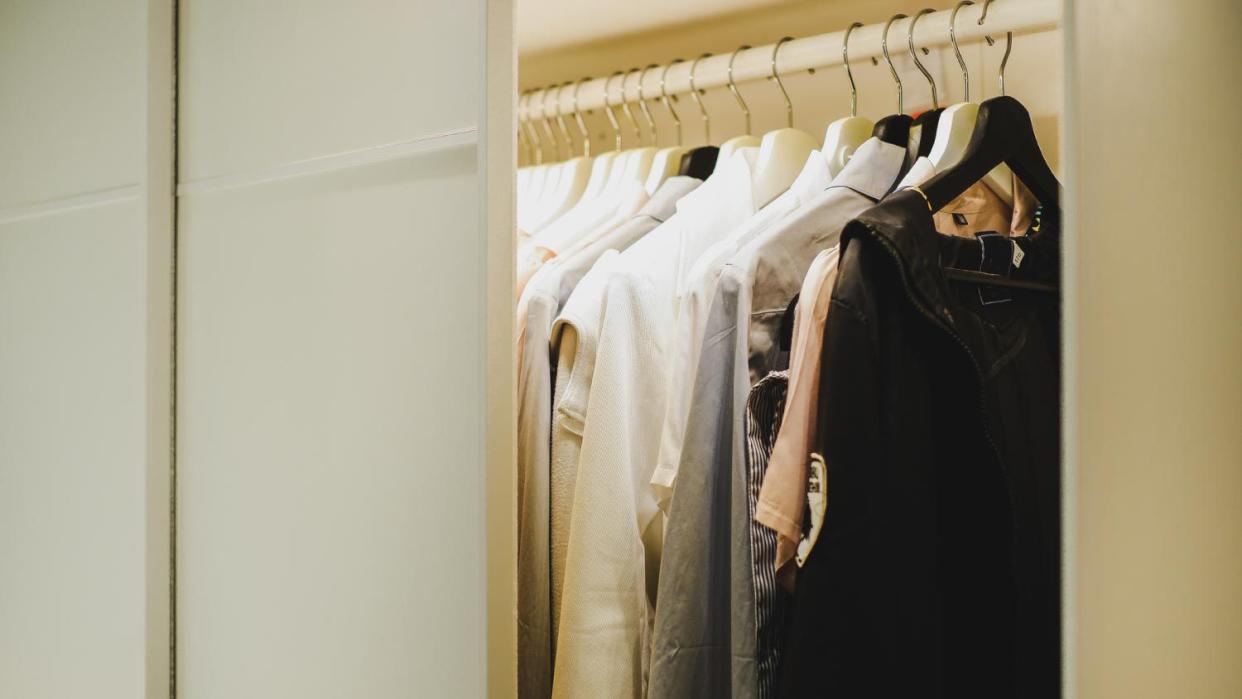 A wardrobe with clothes hanging on the hanger