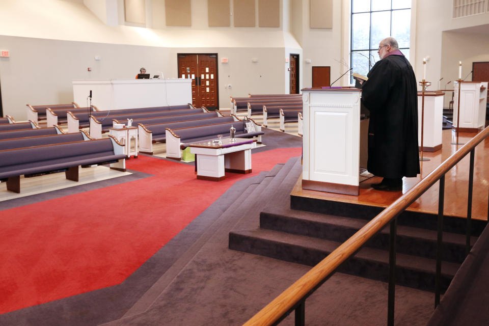 Rev. Kip Rush delivers his sermon in a sanctuary filled with mostly empty pews during a service at Brenthaven Cumberland Presbyterian Church Sunday, March 15, 2020, in Brentwood, Tenn. The church decided to broadcast the service instead of holding a service with the entire congregation because of the coronavirus. (AP Photo/Mark Humphrey)