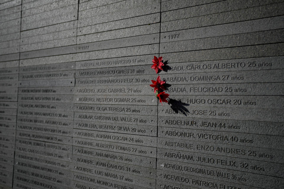 Flowers hang by the names of people who disappeared during Argentina's military dictatorship (1976 - 1983) at Memory Park in Buenos Aires, Argentina, Sunday, Jan. 28, 2024. Human rights organizations report that 30,000 people disappeared during that period. (AP Photo/Natacha Pisarenko)