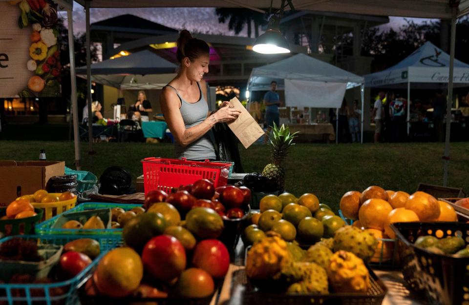 Chef Kelly Dakis sacks some pineapples she sold at Chef Kelly's Produce at the Abacoa Green Market last October. The market kicks off its second season tonight.