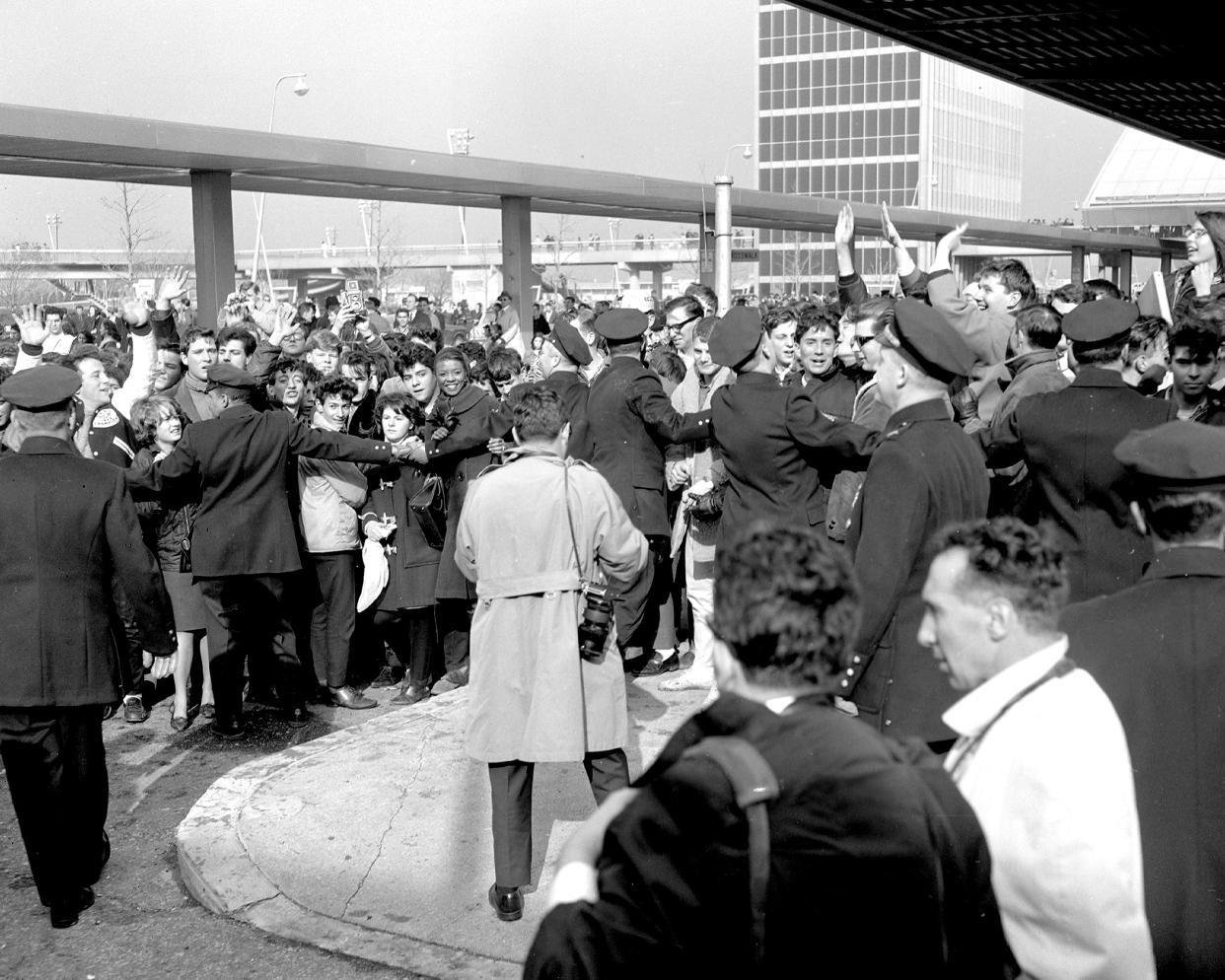 Beatles fans are restrained by police at Kennedy Airport