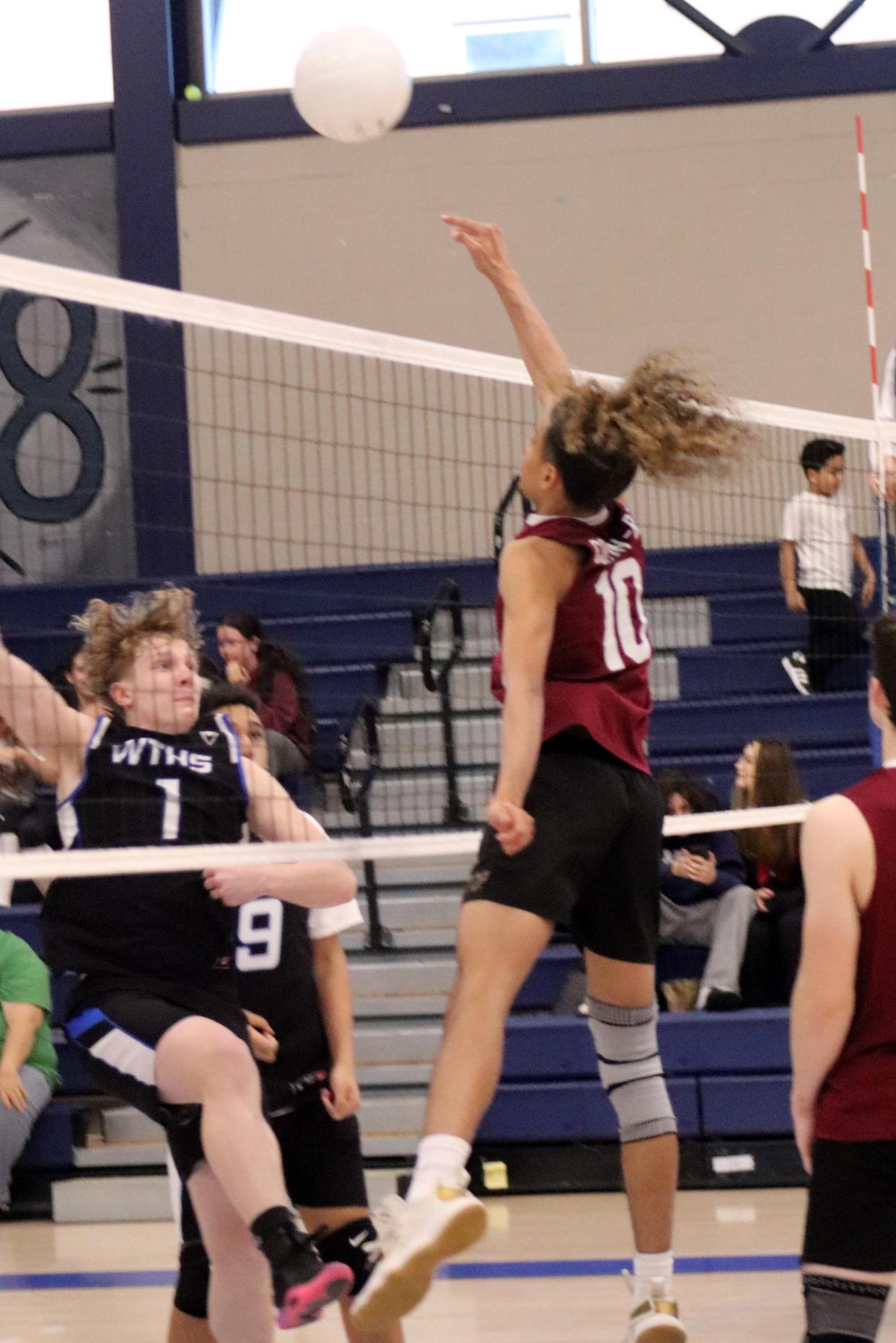 Doherty's Christian Colon-Baez powers the ball over the net as Worcester Tech's Liam Dancy defends.