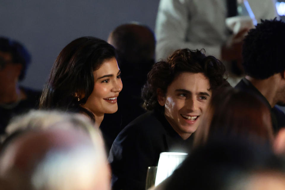 Kylie Jenner and Timothée Chalamet are seated and smiling at an event