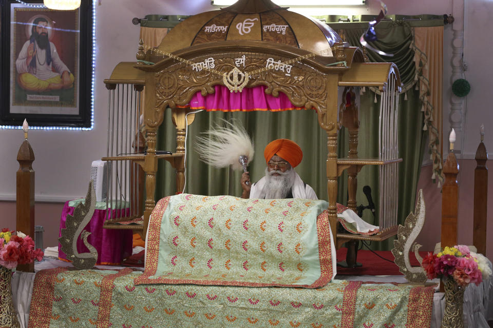 ***HOLD FOR RELIGION TEAM STORY*** Priest (Bhai) Ram Singh is shown performing rituals by the Holy Book during the Shri Guru Ravidass Sabha ceremony at a temple in Fresno, Calif. Sunday, May 7, 2023. Members of the Ravidassia community in California are followers of Guru Ravidass, a 14th century Indian guru of a caste formerly considered untouchable. The Ravidassia community statewide is advocating for new legislation to outlaw caste-based discrimination. (AP Photo/Gary Kazanjian)