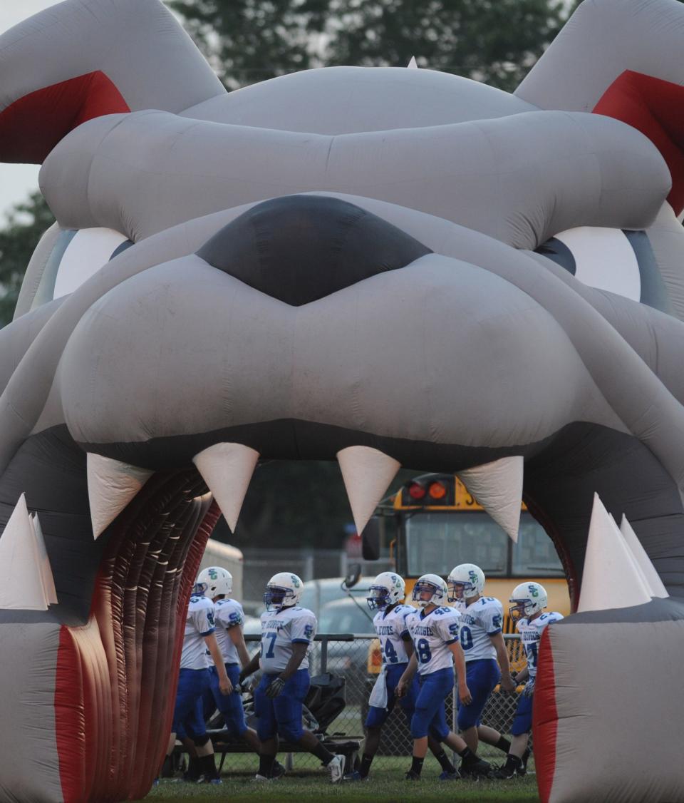 The Laurel mascot appears to be dining on Saint Georges players before a football game.