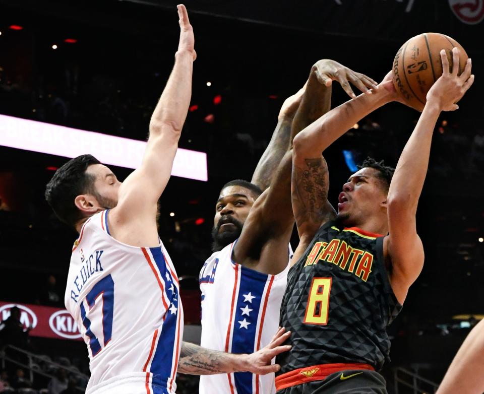 Atlanta Hawks guard Damion Lee (8) shoots as Philadelphia 76ers guard JJ Redick (17) and center Amir Johnson defend during the first half of an NBA basketball game Tuesday, April 10, 2018, in Atlanta. (AP Photo/John Amis)