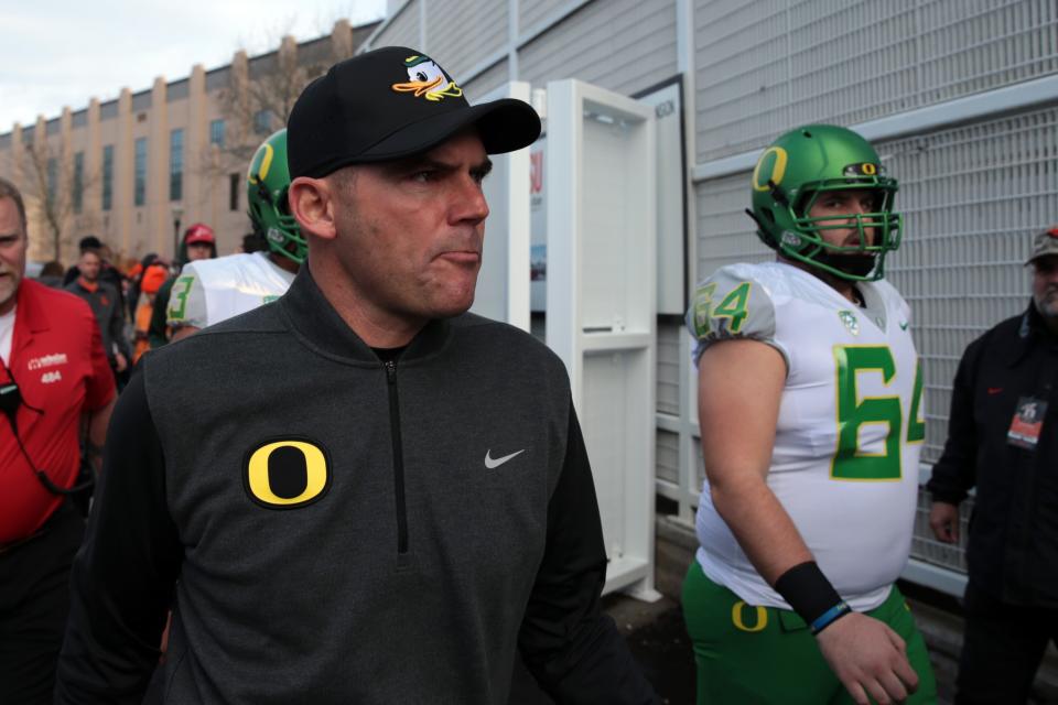Oregon Ducks head coach Mark Helfrich and Oregon Ducks offensive lineman Charlie Landgraf (64) walk from the locker room to the field before the game against the Oregon State Beavers at Reser Stadium.
