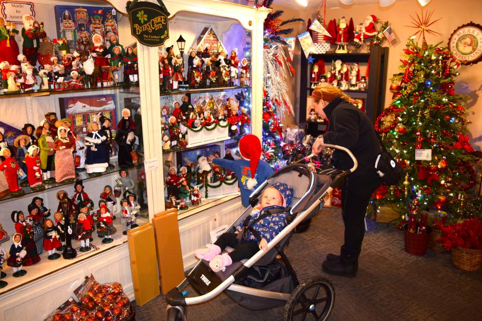 Samantha Hatt and her children Edwin and Clara Miller look over some of the dolls on display at Tis the Season in Berlin.