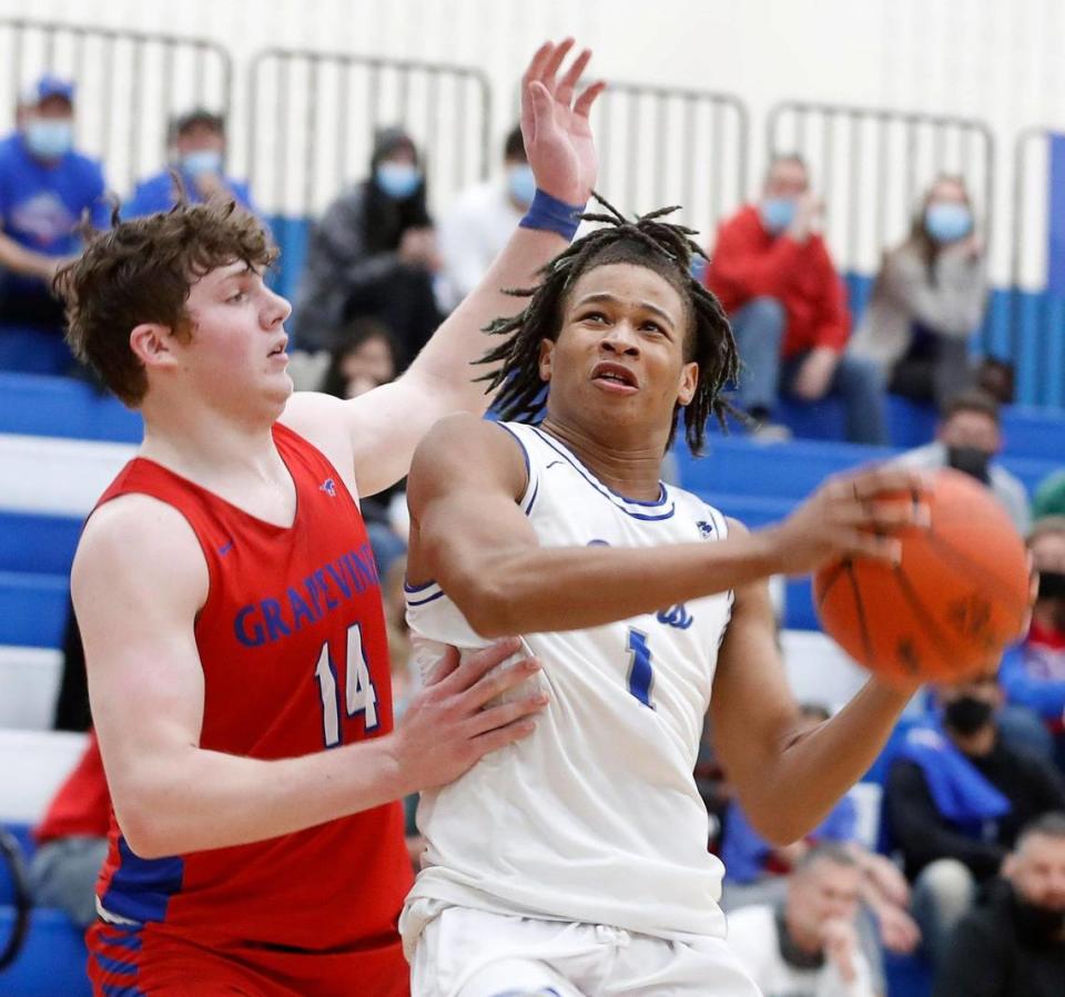 Grapevine center Cole Calvery (14) defends the shot of Brewer forward Draquan Conley (1) during the first half of a 5A Region 1 bi-district basketball game at Brewer High School in Fort Worth, Texas, Monday, Feb. 22, 2021. Grapevine led Brewer by two at the half. (Special to the Star-Telegram Bob Booth)