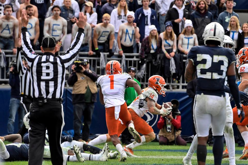 Illinois wide receiver Casey Washington (14) after catching a pass for a 2-point conversion in the ninth overtime to defeat Penn State 20-18 in an NCAA college football game in State College, Pa.on Saturday, Oct. 23, 2021. (AP Photo/Barry Reeger)