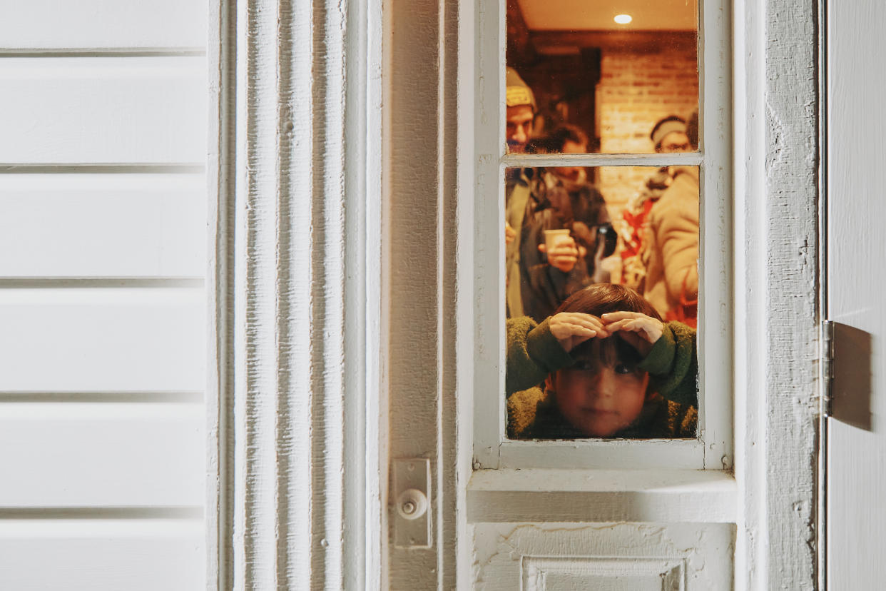 Un niño mira desde una puerta en Churchtown Dairy en Hudson, Nueva York, donde las vacas reciben una serenata con villancicos en un evento anual, el 16 de diciembre de 2023. (Alexandra Genova/The New York Times)
