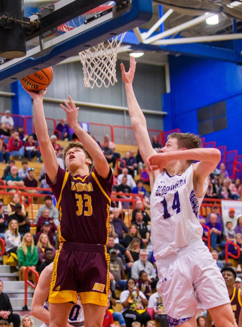 North's Lucas Vencel (33) shoots in front of South's Gavin Wisley (14) during the Bloomington North versus Bloomington South boys basketball sectional final at Martinsville High School on Saturday, March 5, 2022.