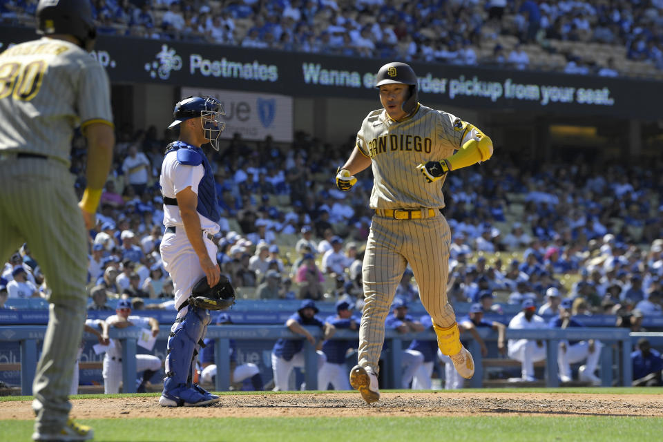 San Diego Padres' Ha-Seong Kim, right, celebrates with Eric Hosmer, left, after hitting a two-run home run as Los Angeles Dodgers catcher Austin Barnes stands at the plate during the ninth inning of a baseball game Sunday, July 3, 2022, in Los Angeles. (AP Photo/Mark J. Terrill)