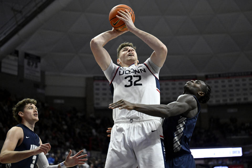 UConn's center Donovan Clingan (32) looks to shoot over New Hampshire forward Clarence Daniels, right, as New Hampshire forward Jaxson Baker, left, defends in the second half of an NCAA college basketball game, Monday, Nov. 27, 2023, in Storrs, Conn. (AP Photo/Jessica Hill)