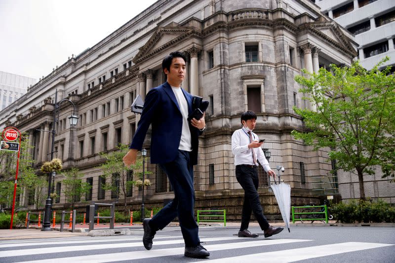 FILE PHOTO: People walk in front of the bank of Japan building in Tokyo