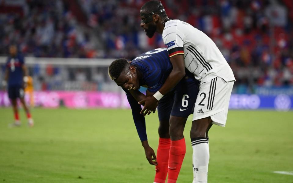 Paul Pogba winces in pain after his coming-together with Antonio Rudiger - REUTERS
