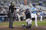 An umpire, left, signals for a strike after being told a strike call through an earpiece as the St. Paul Saints' Kyle Farmer, right, bats during the second inning of a minor league baseball game against the Nashville Sounds, Friday, May 5, 2023, in St. Paul, Minn. Automatic balls and strikes could soon be coming to the major leagues. Much like the players themselves, robo-umps are working their way up through the minors with the goal being promoted to the show. (AP Photo/Abbie Parr)