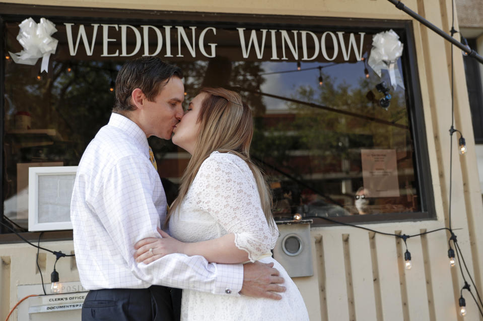 Justin and Joanne Waters kiss after they were married in a walk up and drive-thru wedding ceremony at the Family and Civil courthouse in Gainesville, Fla. Thursday, May 14, 2020. (AP Photo/John Raoux)