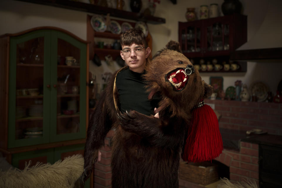Madalin, 16 years-old, a member of the Sipoteni bear pack, poses for a portrait in Comanesti, northern Romania, Wednesday, Dec. 27, 2023. Madalin first wore the bear fur costume when he was 4 years-old and feels proud to continue a tradition that goes back in his family for generations. (AP Photo/Andreea Alexandru)