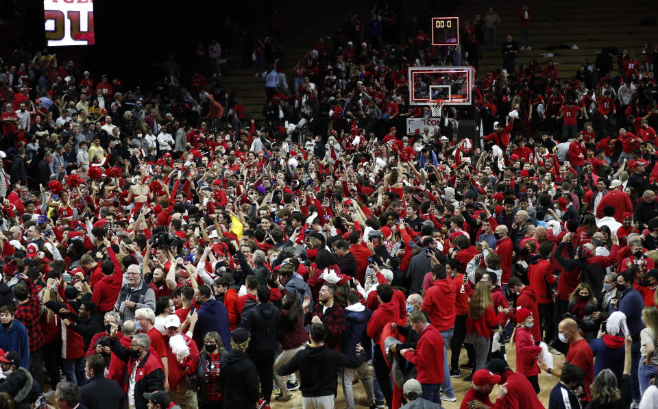 Fans gather on the court after Rutgers defeated Purdue 70-68 during an NCAA college basketball game in Piscataway, N.J., Thursday, Dec. 9, 2021. (AP Photo/Noah K. Murray)