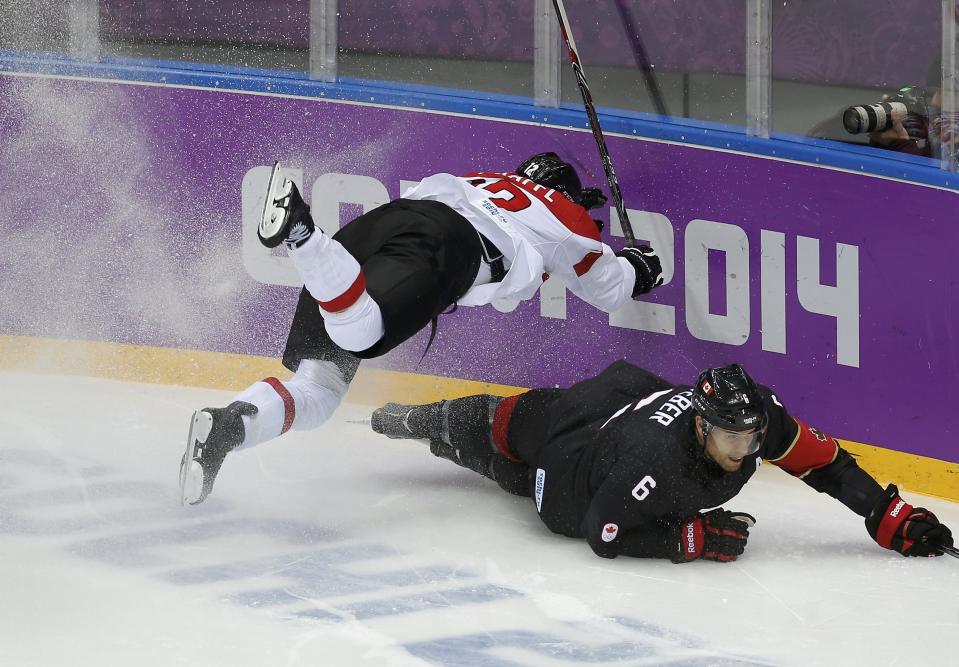 Austria's Michael Raffl flies over Canada's Shea Weber during the second period of their men's preliminary round ice hockey game at the Sochi 2014 Sochi Winter Olympics, February 14, 2014. REUTERS/Jim Young (RUSSIA - Tags: TPX IMAGES OF THE DAY OLYMPICS SPORT ICE HOCKEY)