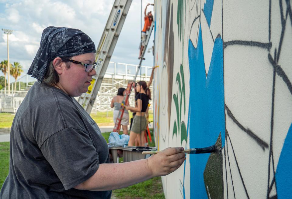 Art teacher Mel Padilla fills in a section of a mural at Leesburg High School in Leesburg on Tuesday, May 24, 2022. [PAUL RYAN / CORRESPONDENT]