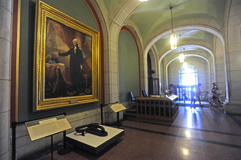 In this July 31, 2012 photo, a portrait of George Washington and links from a chain that spanned the Hudson River at West Point are on display at the Capitol in Albany, N.Y. Historic artifacts that have been kept in storage for years are now on display in the corridors of the Capitol and the adjacent Empire State Plaza. (AP Photo/Tim Roske)