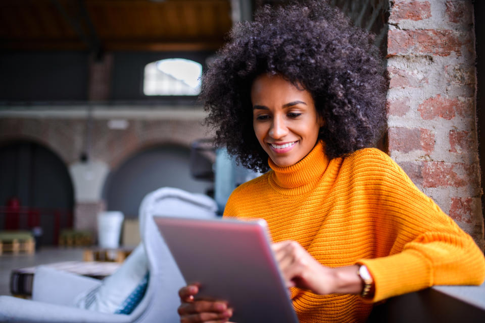 Smiling African American woman using digital tablet.