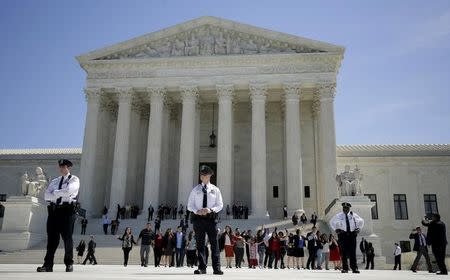 Immigration activists join hands after the U.S. Supreme Court heard arguments in a challenge by 26 states over the constitutionality of President Barack Obama's executive action to defer deportation of certain immigrant children and parents who are in the country illegally, in Washington April 18, 2016. REUTERS/Joshua Roberts