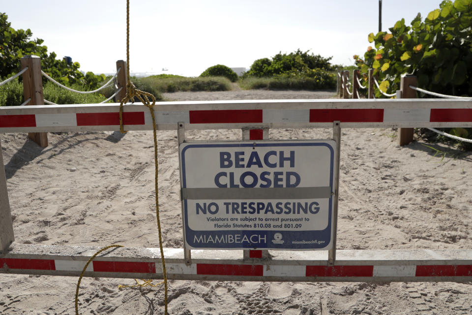 A sign is posted at a closed entrance to the beach during the new coronavirus pandemic, Friday, July 3, 2020, in the South Beach neighborhood of Miami Beach, Fla. Beaches throughout South Florida are closed for the busy Fourth of July weekend to avoid further spread of the new coronavirus. (AP Photo/Lynne Sladky)