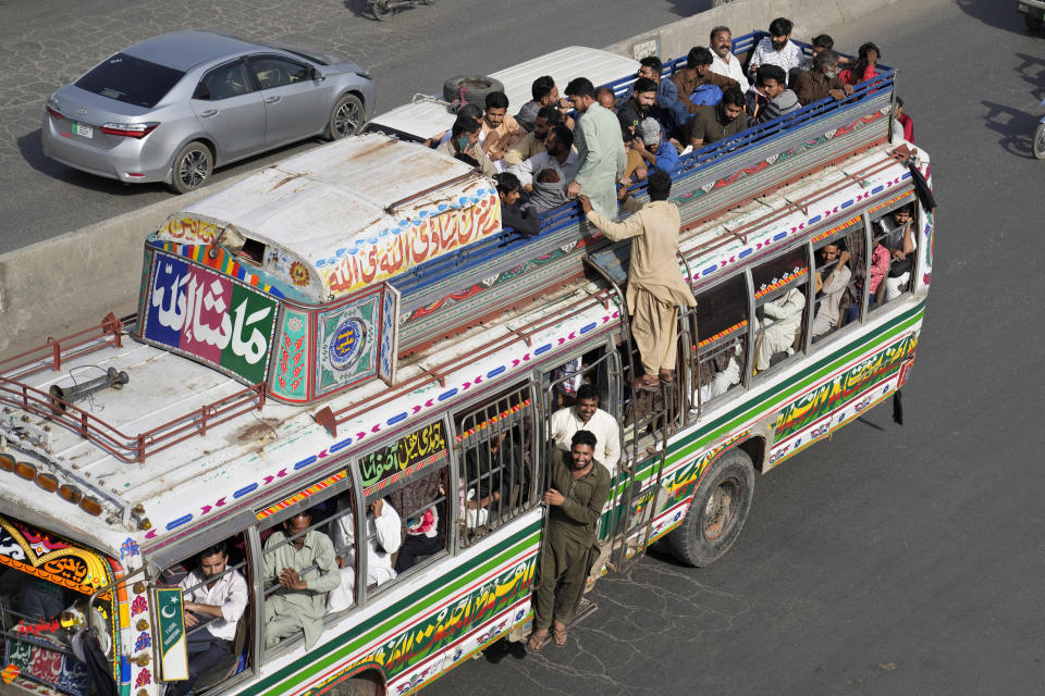 People travel on an over loaded bus to reach their villages and cities to celebrate the upcoming Eid al-Fitr holidays, marking the end of the Islamic holy month of Ramadan, in Lahore, Pakistan, Thursday, April 20, 2023.