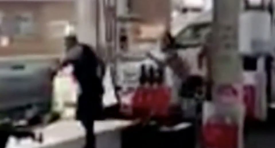 One of the police officers sprints away as the man sets chase at a Toronto petrol station