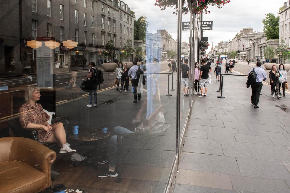 Residents enjoy a coffee in Aberdeen, eastern Scotland. (AFP via Getty Images)