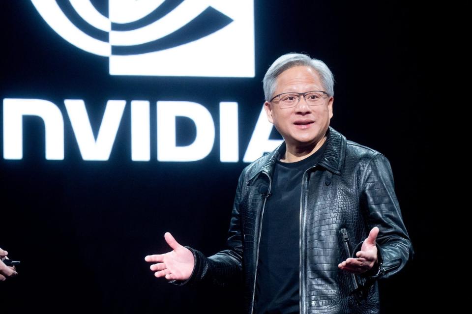 Jensen Huang in front of the Nvidia logo.