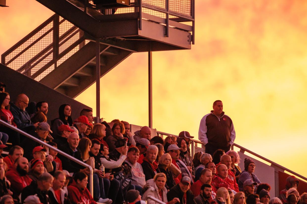 The Dover fan section is illuminated by a classic Ohio Fall sunset during the game against DeSales, Friday, Sept. 30 at Crater Stadium in Dover.
