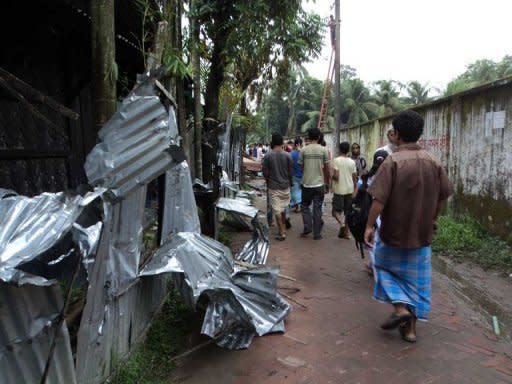 People walk past the ransacked homes of Buddhists in Ramu. Buddhists, who make up less than one percent of Bangladesh's 153 million population, are based mainly in southeastern districts, close to the border with Buddhist-majority Myanmar