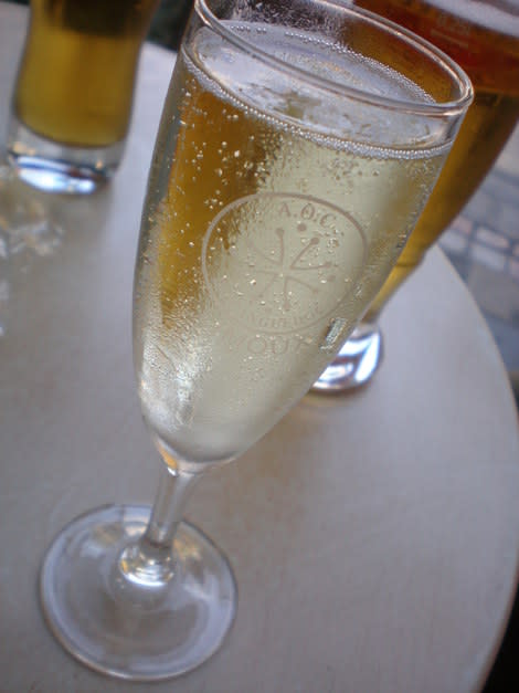 A glass of sparkling wine is served on a table.