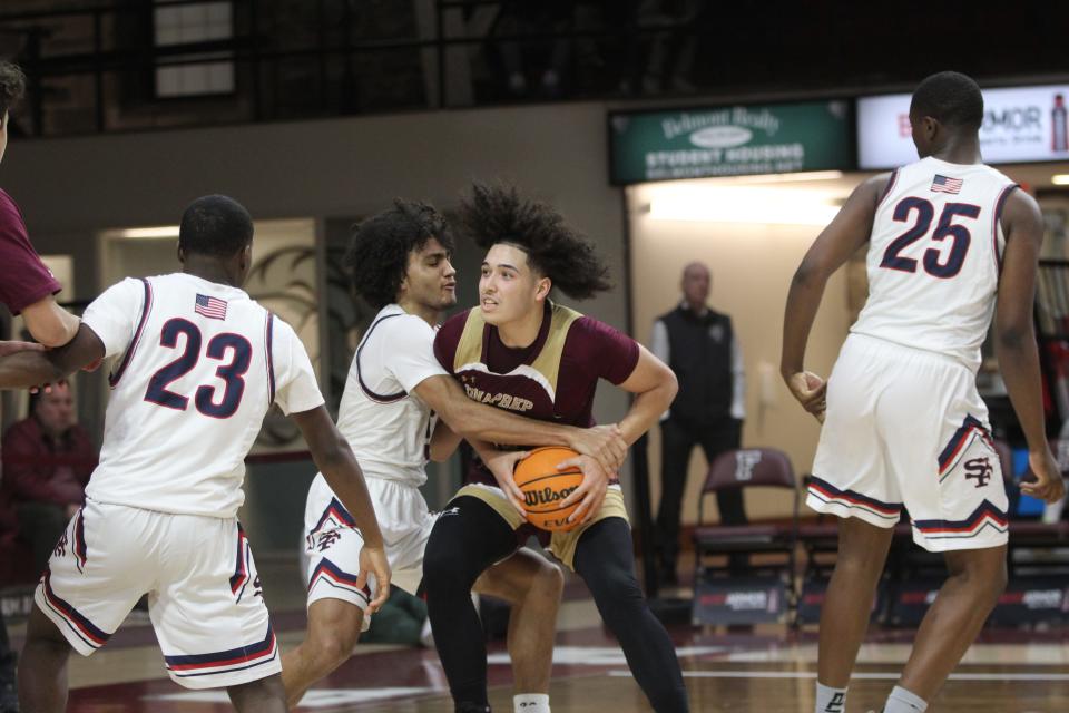 Iona Prep's A.J. Rodriguez (red) is fouled while driving to the basket during the CHSAA AA city quarterfinals at Fordham University on March 5, 2023.