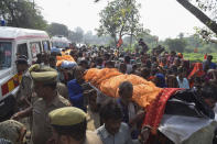 Villagers carry the bodies of victims of a road accident in Kanpur, Uttar Pradesh state, India, Sunday, Oct.2, 2022. A farm tractor pulling a wagon loaded with people overturned and fell into a pond in Kanpur city's Ghatampur area Saturday night killing 26 people, most of them women and children. (AP Photo)