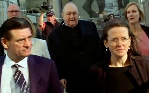 Archbishop Philip Wilson, center, heads to Newcastle Local Court - Credit: Australian Broadcasting Corporation via AP