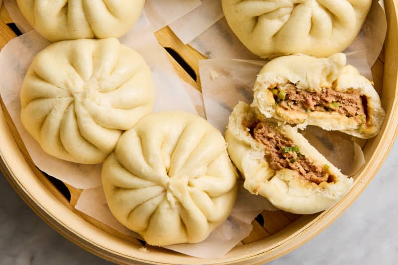 steamed buns on surface with one split open