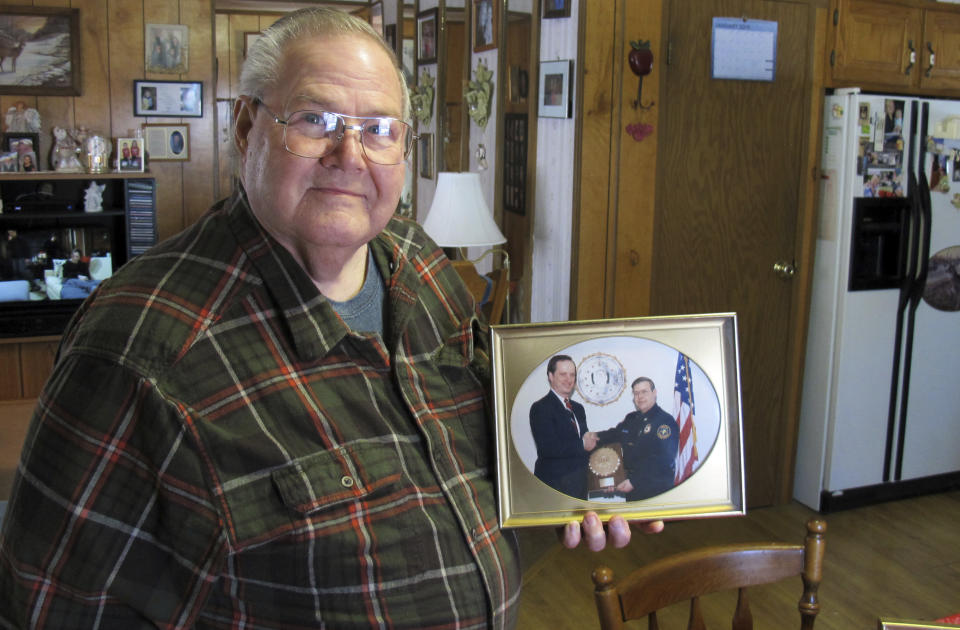 In this Jan. 17, 2019 photo, former Richford police chief Richard Jewett holds a photo of himself in Highgate, Vt., shaking hands with former FBI Director William Sessions. Jewett was being honored for the night in 1987 when he apprehended a man who carried a bomb into the United States from Canada. At a time when terrorism is part of the discussion about whether to build a wall on the U.S. southern border to protect the country, the Richford incident was the only one of its kind when anyone was caught trying to enter the United States illegally as part of a terrorist plot. (AP Photo/Wilson Ring)