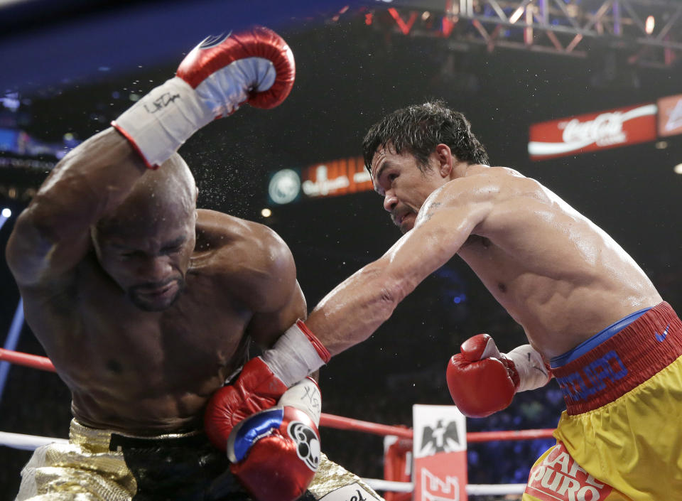 Manny Pacquiao, from the Philippines, right, punches Floyd Mayweather Jr., during their welterweight title fight on Saturday, May 2, 2015 in Las Vegas. (AP Photo/Isaac Brekken)
