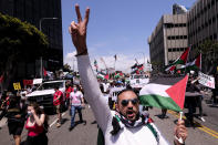 A demonstrator holding the flag of Palestine and showing a peace sign marches with others to the Israeli Consulate during a protest against Israel and in support of Palestinians during the current conflict in the Middle East, Saturday, May 15, 2021, in the Westwood section of Los Angeles. (AP Photo/Ringo H.W. Chiu)